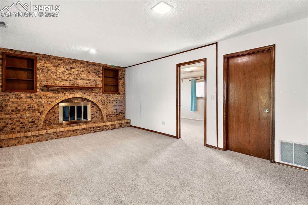 Image 28 of 50: Lower level Family Room with Woodburning Fireplace