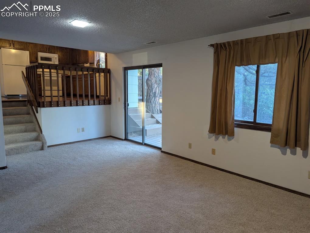 Image 30 of 50: Lower level Family Room looking toward Kitchen, Walk-out to Deck