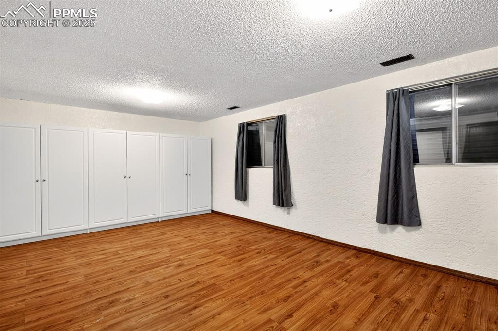 Image 39 of 50: Basement Family Room has wall of storage cabinets