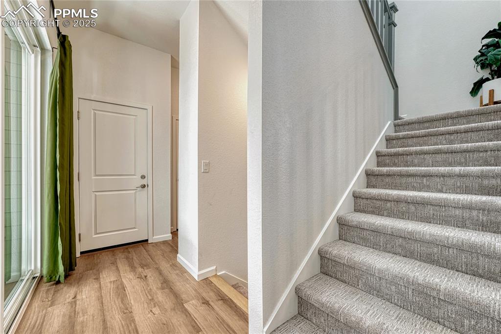 Image 19 of 50: Across from the sliding glass doors to the patio are carpeted stairs to the