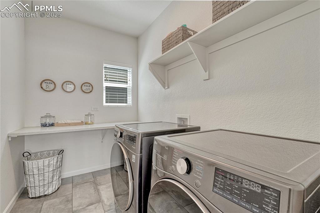 Image 22 of 50: This laundry space has room for large washer/dryer units along with storage
