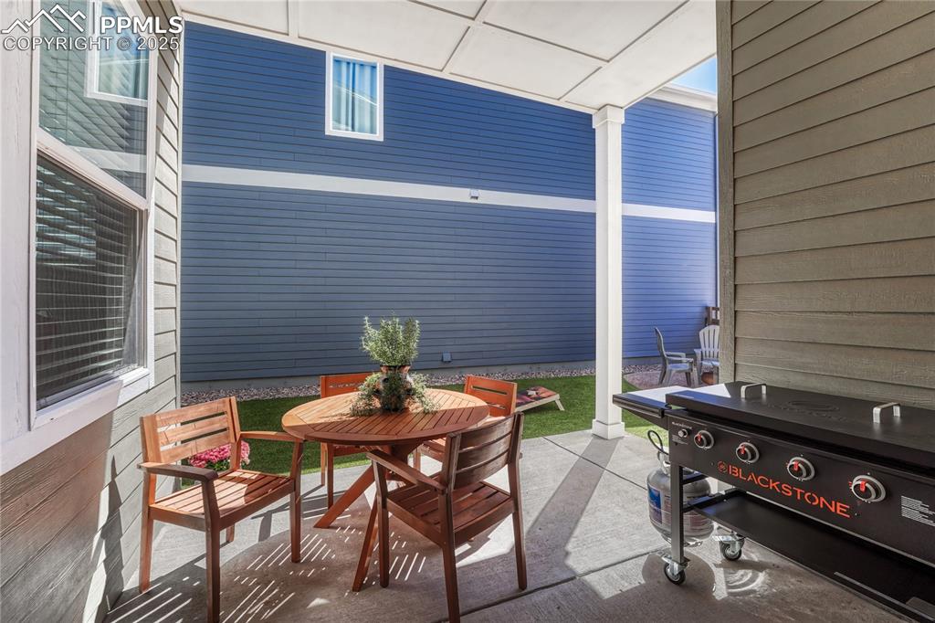 Image 42 of 50: Beyond the patio is a larger side yard that is fenced in with turf and anot