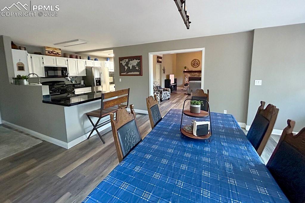 Image 10 of 50: Dining room featuring dark wood-type flooring and baseboards