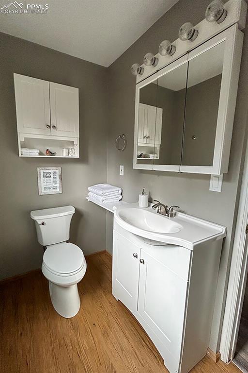 Image 12 of 50: Primary attached half bath featuring light wood-style floors and vanity