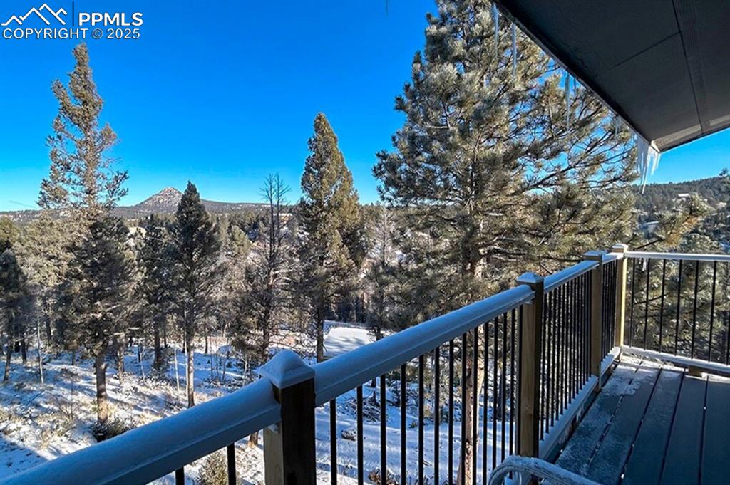 Image 15 of 50: Primary balcony. Snow covered back of property with a mountain view