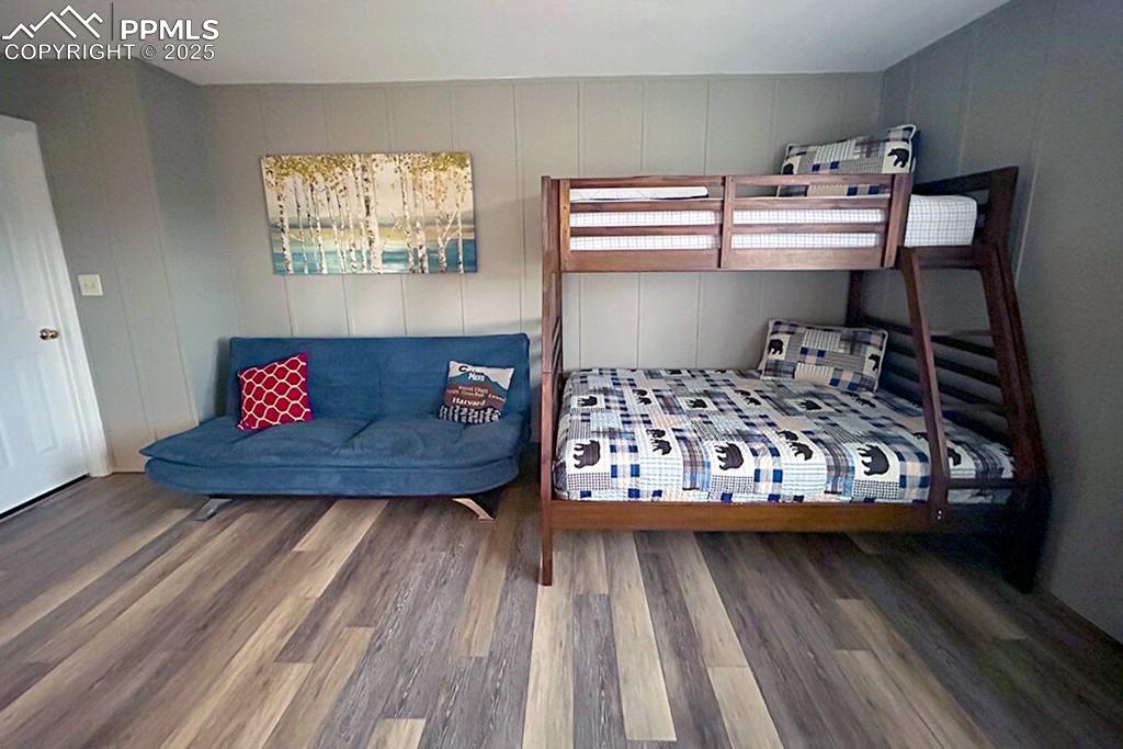 Image 18 of 50: Bedroom with wood finished floors and a decorative wall