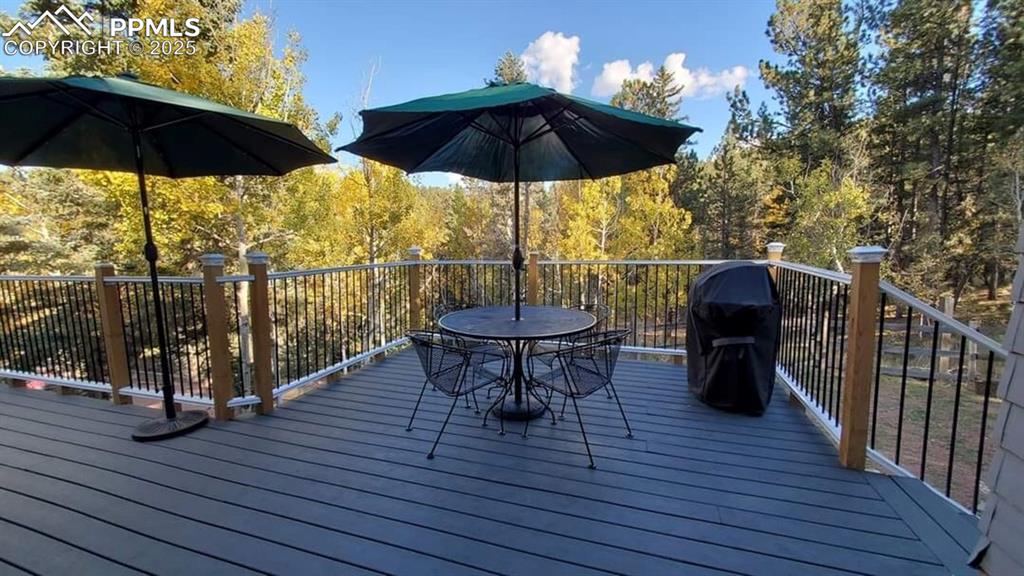 Image 28 of 50: Deck with outdoor dining space and a grill