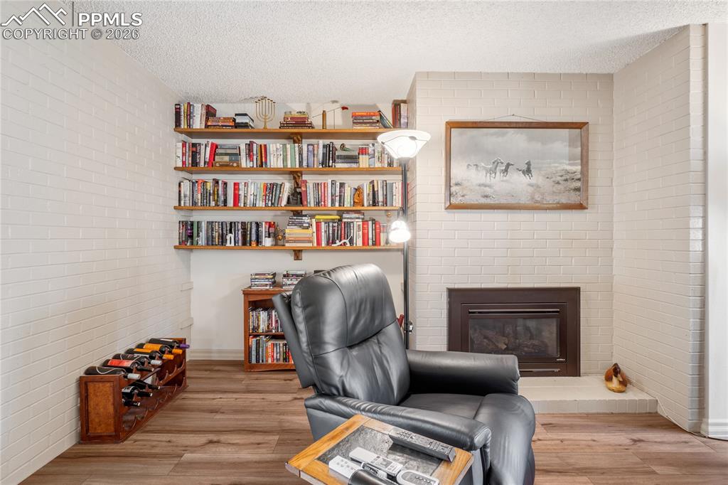 Image 8 of 39: Gas fireplace next to a cozy reading area
