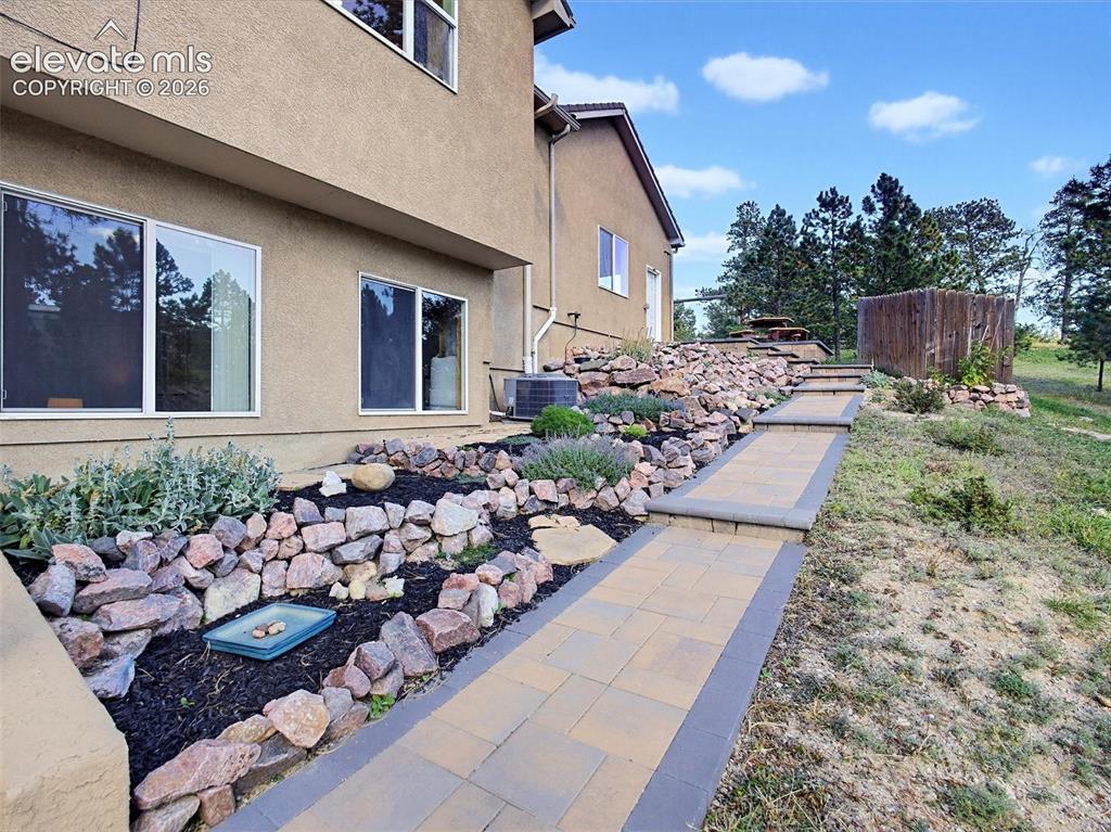 Image 41 of 48: Lovely rock garden with perennials on side yard