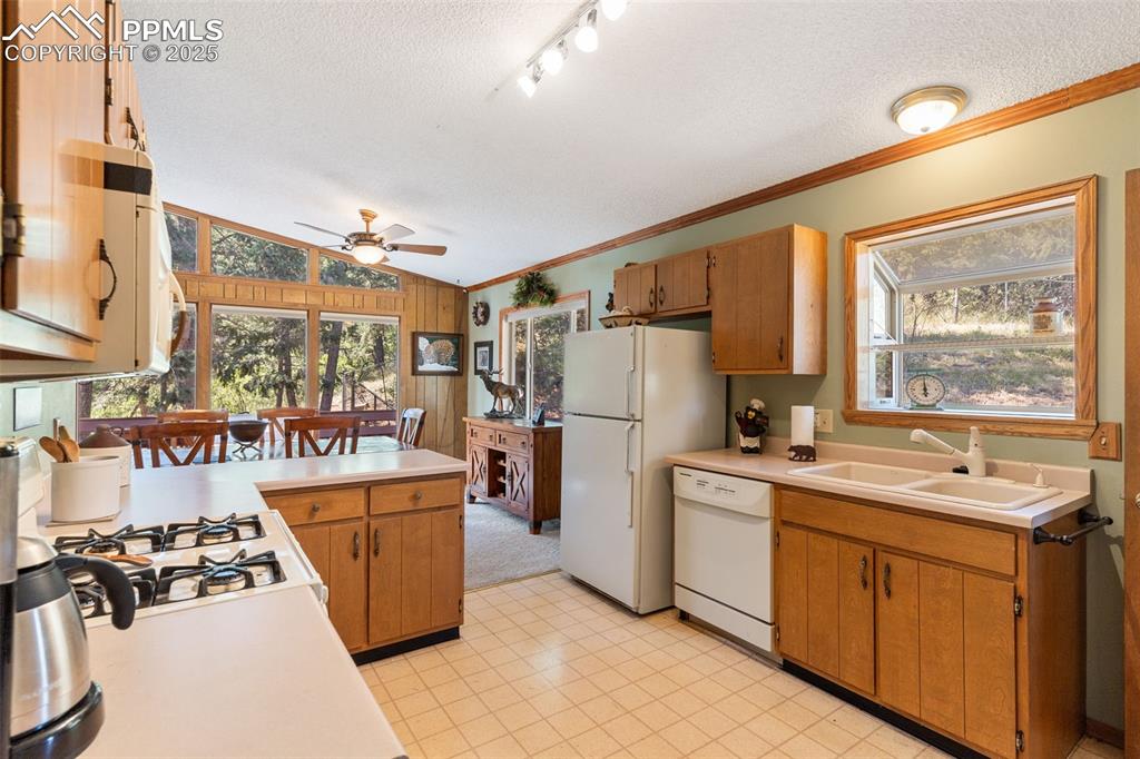 Image 9 of 35: Kitchen with a textured ceiling, lofted ceiling, light countertops, crown m