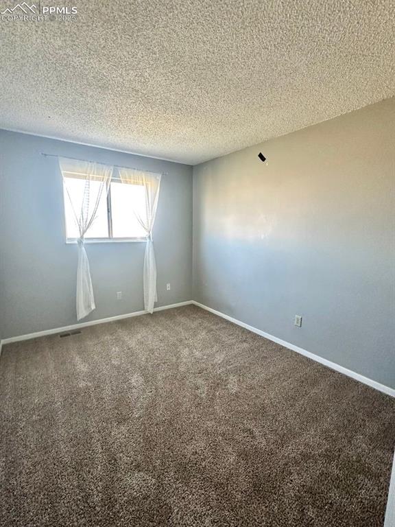 Image 12 of 13: Unfurnished room featuring carpet flooring and a textured ceiling