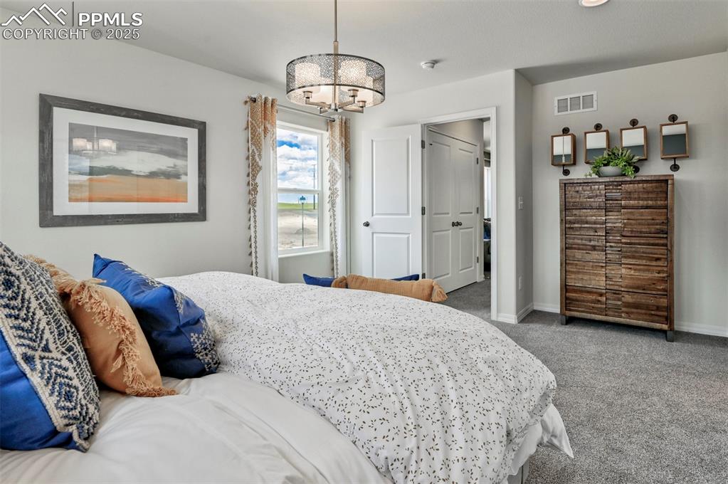 Image 19 of 35: Bedroom featuring carpet and a chandelier