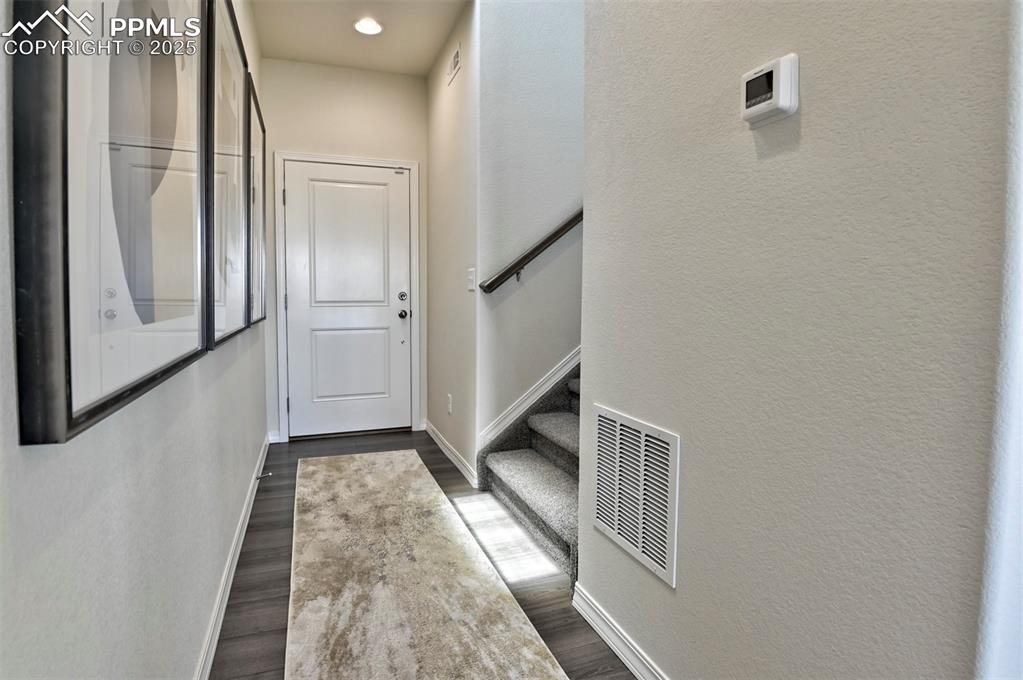 Image 22 of 35: Doorway with wood finished floors and a textured wall