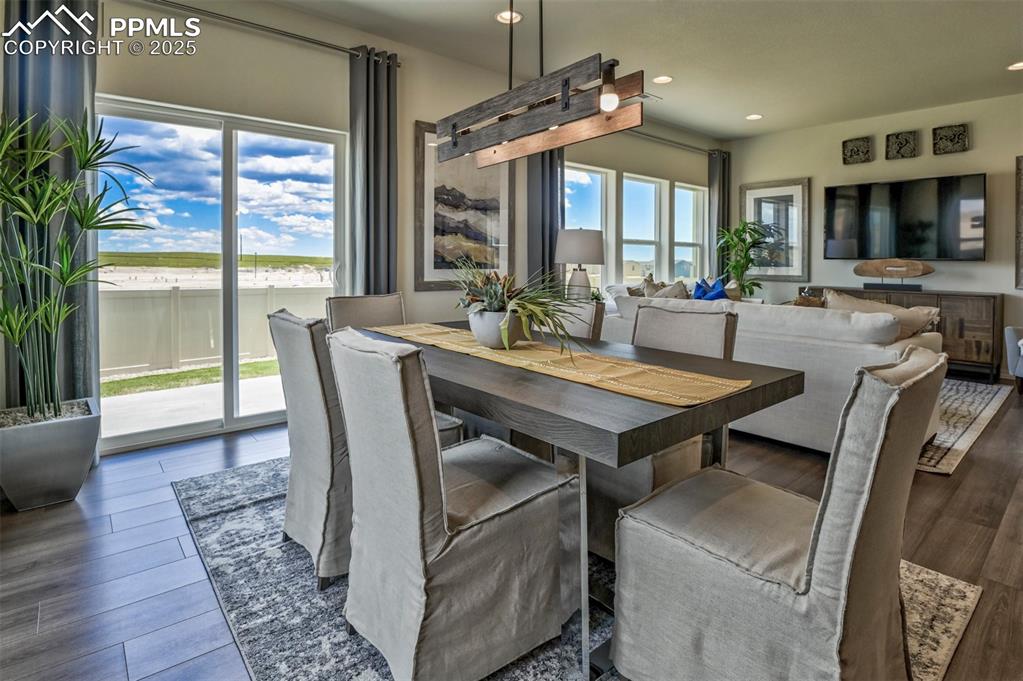 Image 28 of 35: Dining space with dark wood finished floors, recessed lighting, and a water