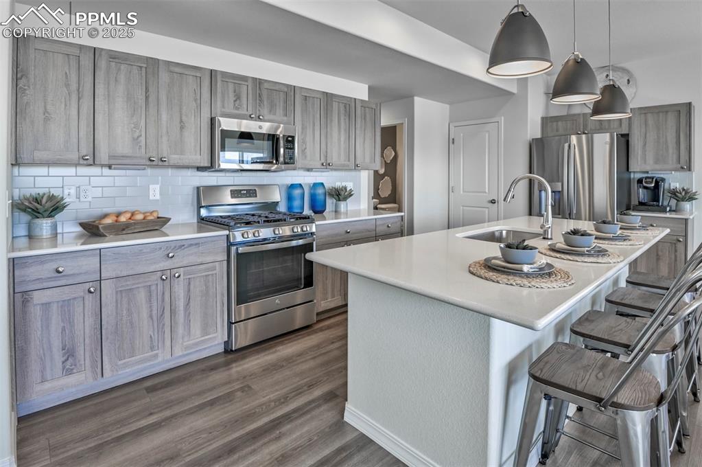 Image 31 of 35: Kitchen featuring appliances with stainless steel finishes, tasteful backsp