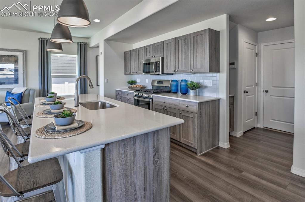 Image 32 of 35: Kitchen with appliances with stainless steel finishes, decorative light fix