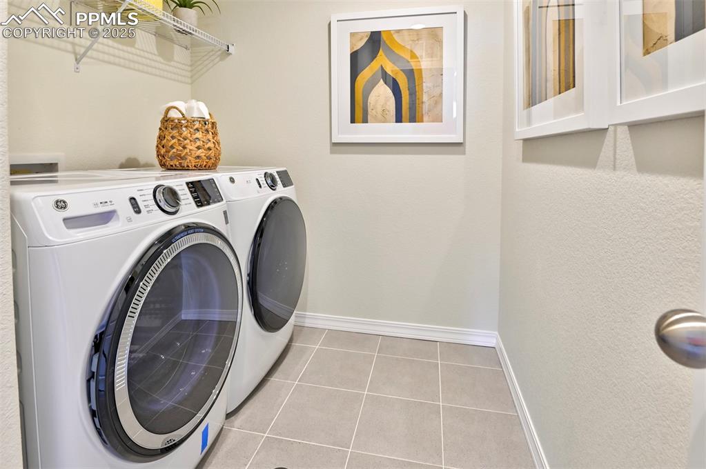 Image 8 of 35: Laundry room with light tile patterned floors and independent washer and dr