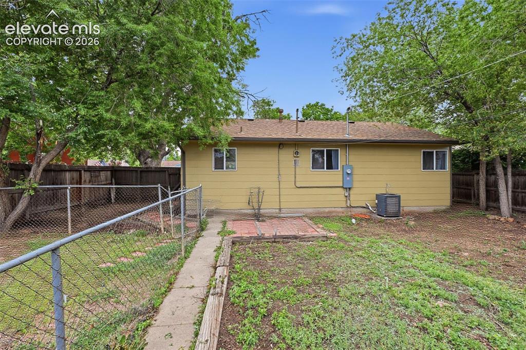 Image 19 of 22: View of back of home and updated electric panel and new A/C
