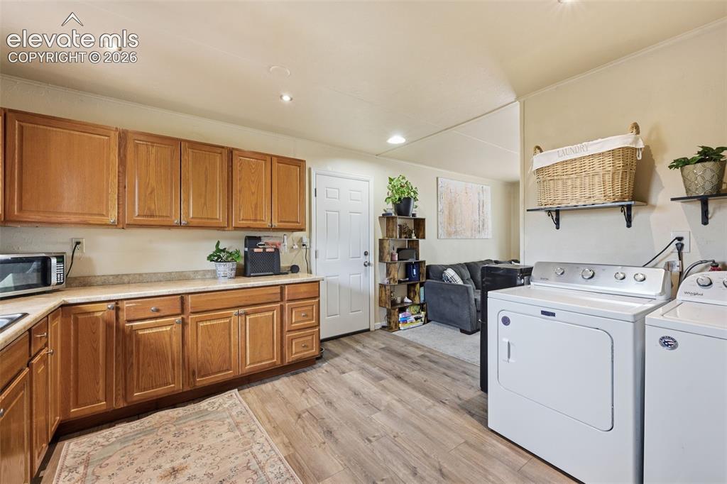 Image 6 of 22: Kitchen with view towards back door to back yard