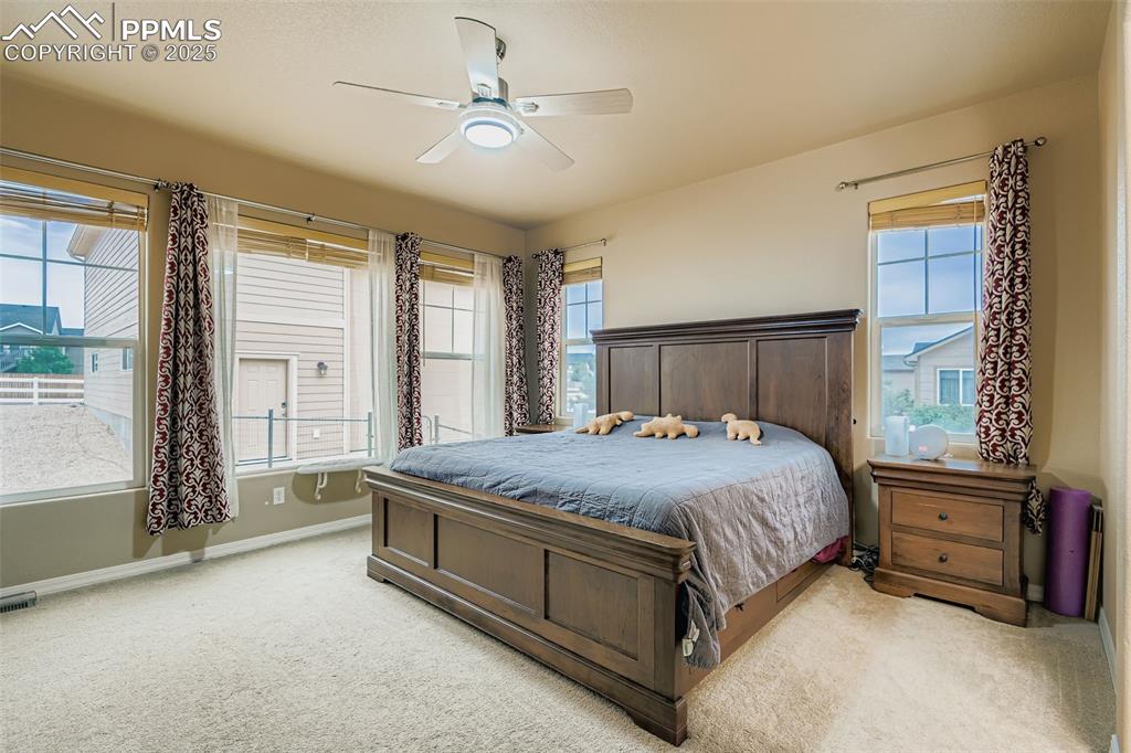 Image 12 of 28: Carpeted bedroom with baseboards and a ceiling fan