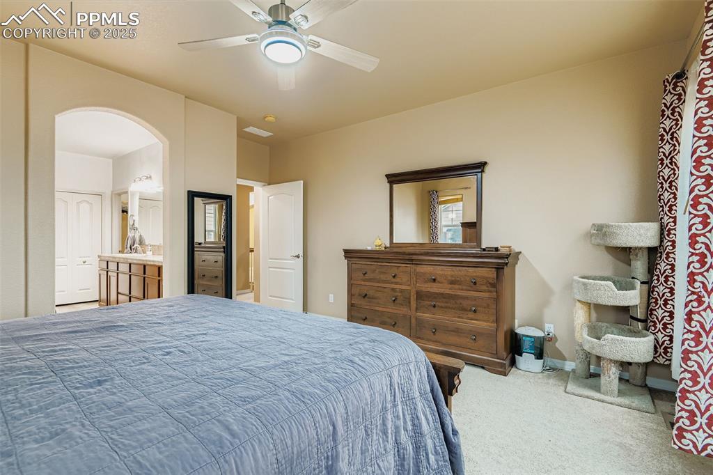 Image 13 of 28: Bedroom with carpet, ceiling fan, and arched walkways