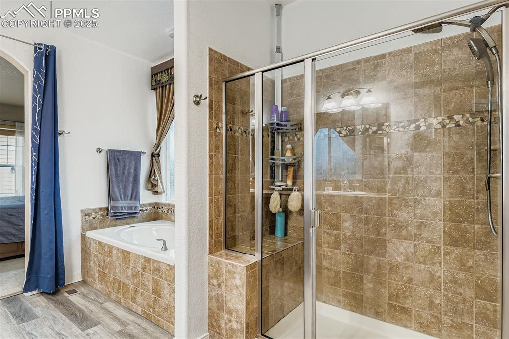 Image 15 of 28: Primary Bathroom featuring a garden tub, and a large separate stand up show