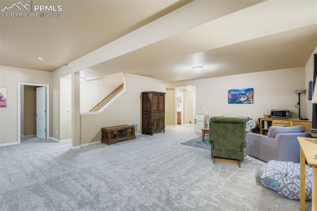 Image 19 of 28: Carpeted living room with baseboards