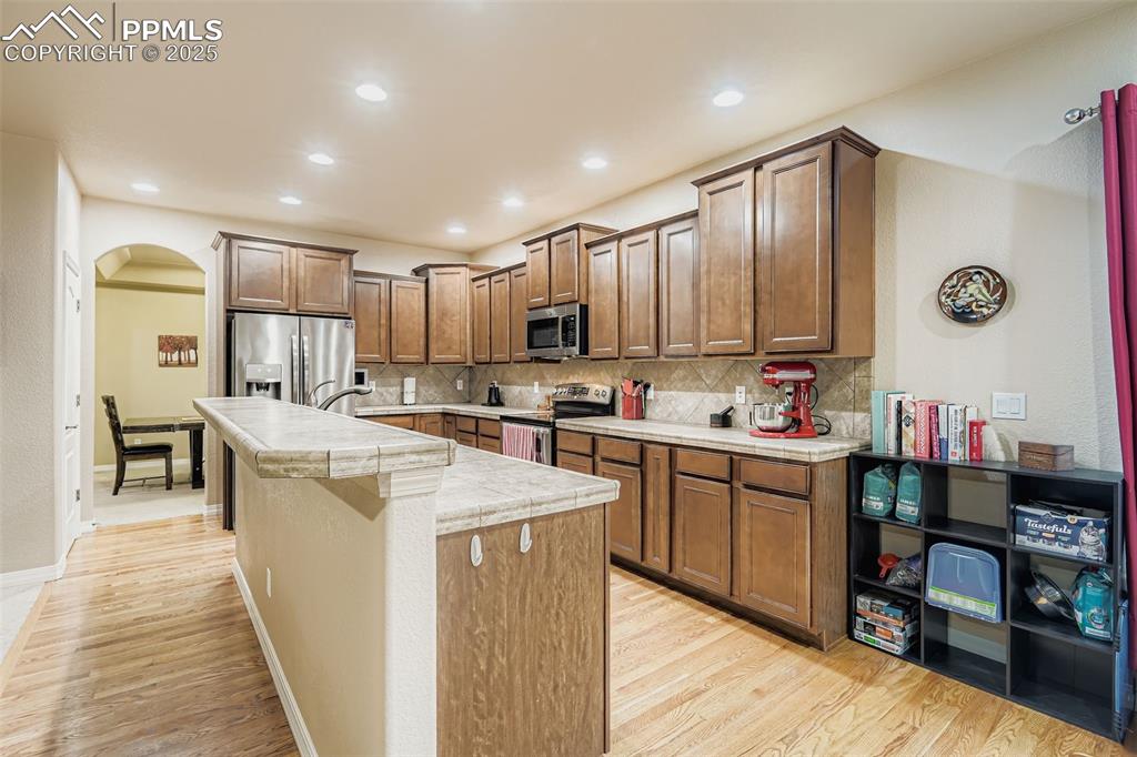 Image 9 of 28: Kitchen featuring tasteful backsplash, arched walkways, stainless steel app