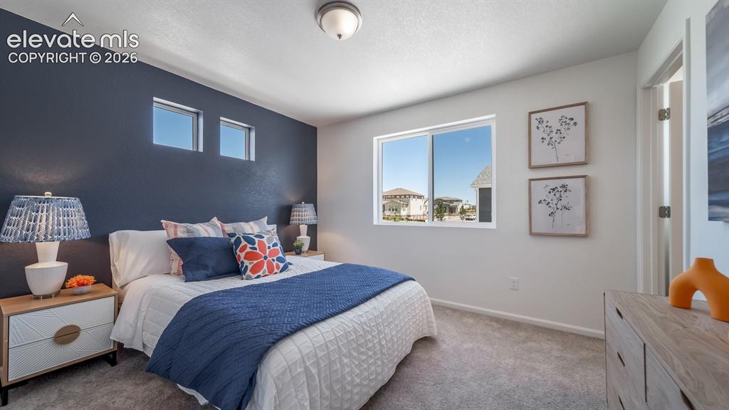 Image 24 of 26: Bedroom featuring a dark accent wall with two upper windows, a large slidin