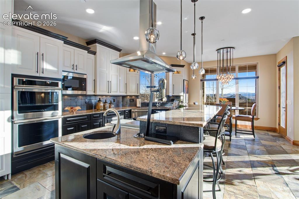 Image 21 of 50: Center two-tier island with breakfast bar