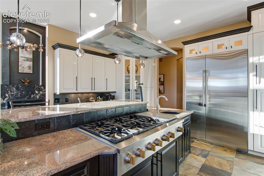 Image 22 of 50: Gas range with flat grill and commercial hood