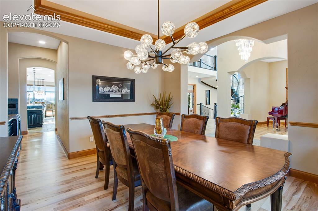 Image 24 of 50: Front formal dining room features a tray ceiling, crown molding and rope li