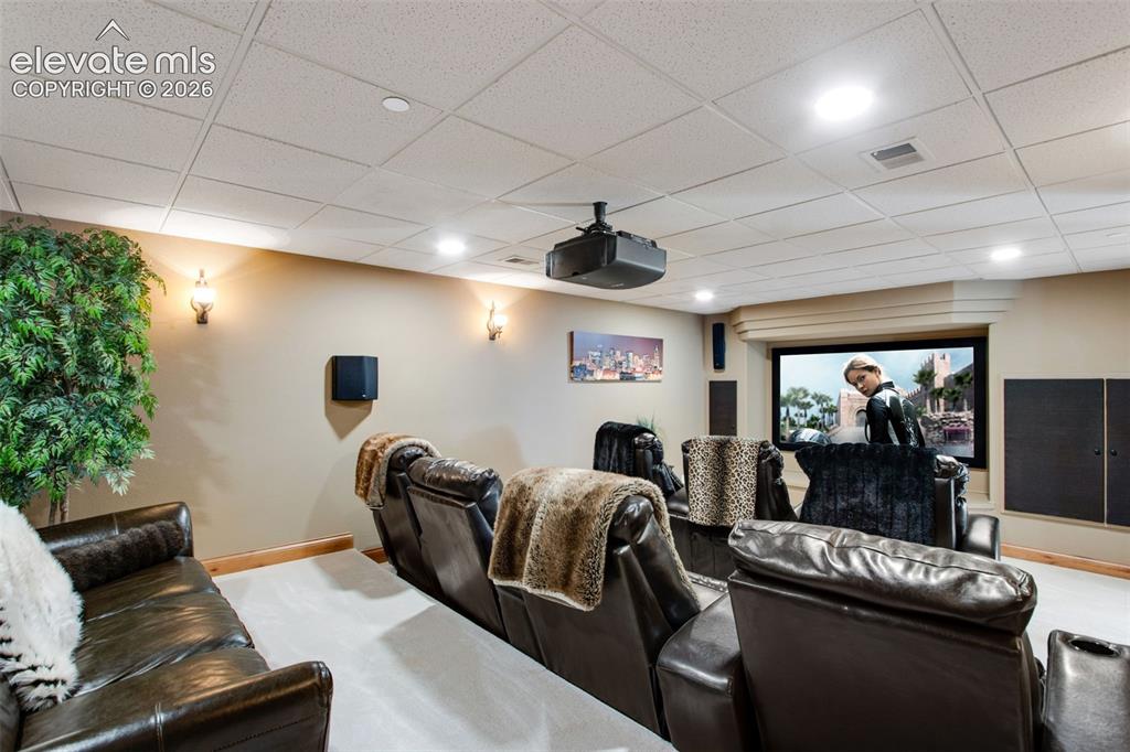 Image 42 of 50: Theater room with stadium seating features a projector, screen, 7 recliners