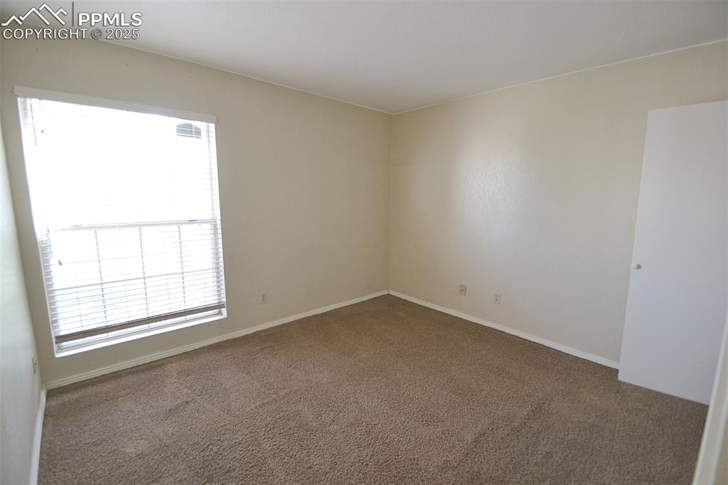Image 13 of 31: Empty room with carpet floors and baseboards