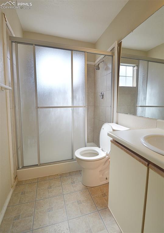 Image 17 of 31: Bathroom featuring vanity, a stall shower, and light stone finish floors