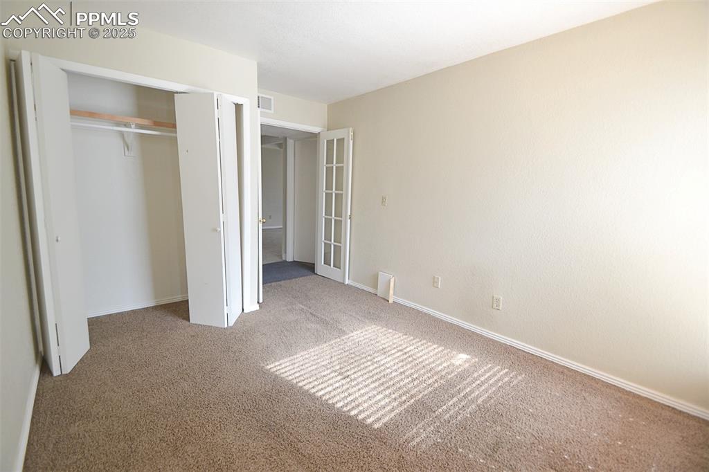 Image 21 of 31: Unfurnished bedroom featuring carpet flooring, a closet, and french doors