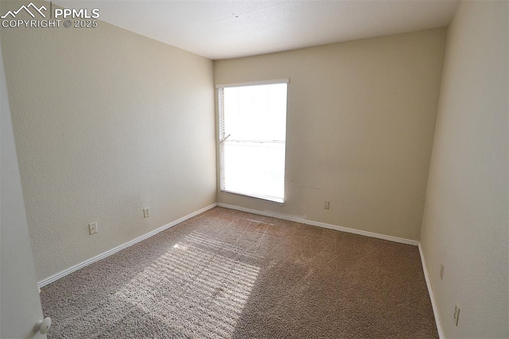 Image 22 of 31: Empty room with carpet and a textured wall