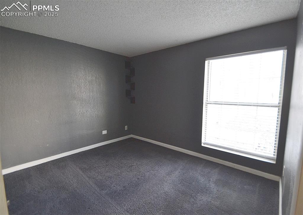Image 25 of 31: Carpeted spare room with baseboards and a textured ceiling