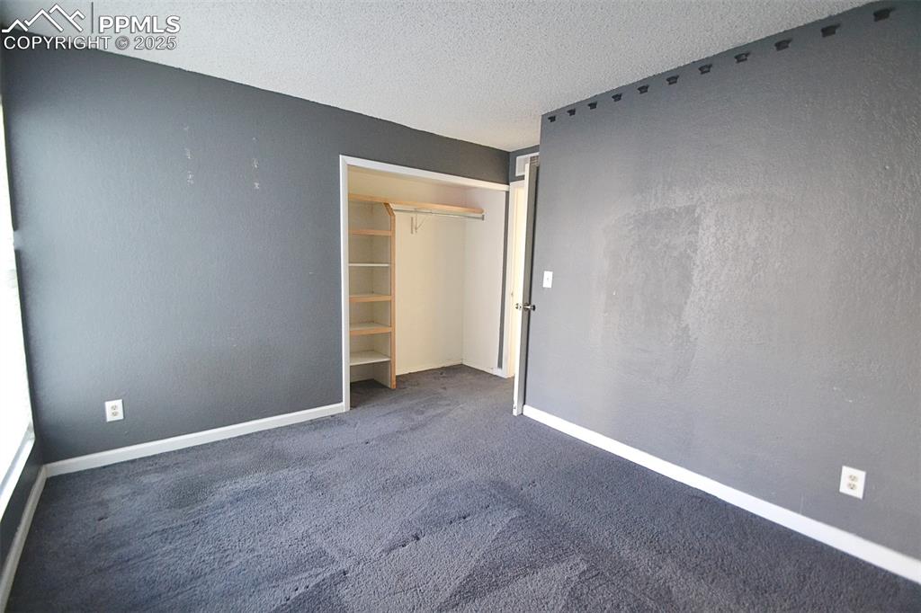 Image 27 of 31: Unfurnished bedroom featuring carpet flooring, a textured ceiling, and a cl