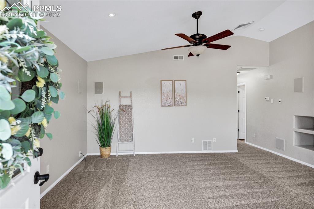 Image 5 of 39: Carpeted with built-ins and Surround Sound, ceiling fan and high vaulted ce