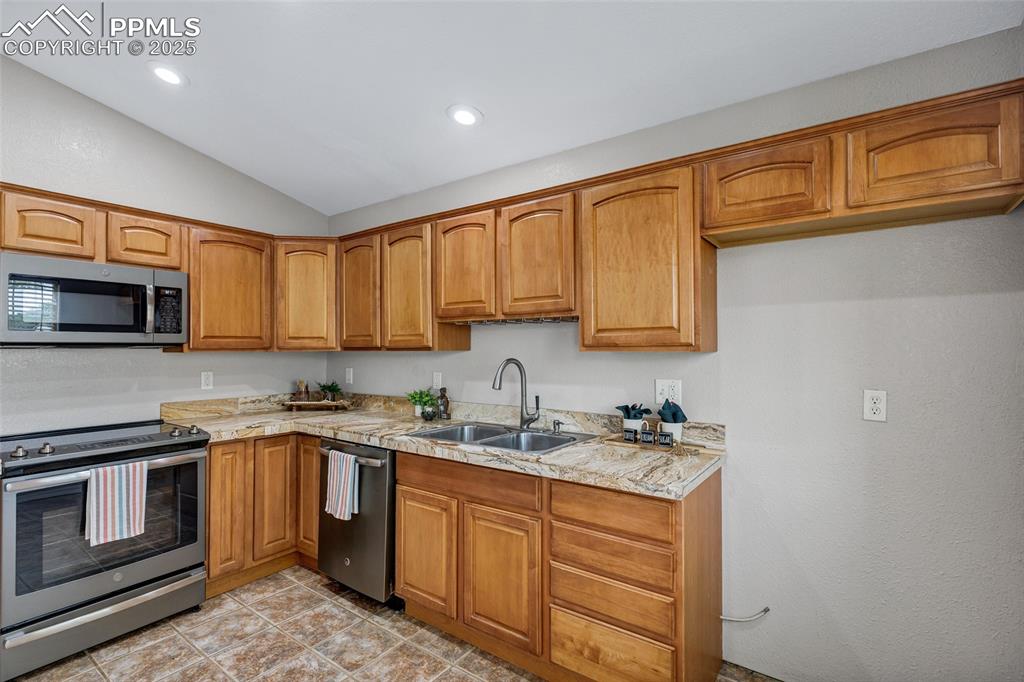 Image 8 of 39: Lofted ceiling, bright window & can lighting countertops, stainless steel a