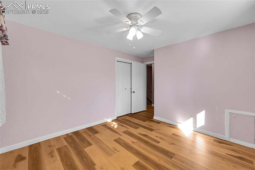 Image 12 of 27: Unfurnished bedroom with light wood-type flooring, a ceiling fan, and a clo