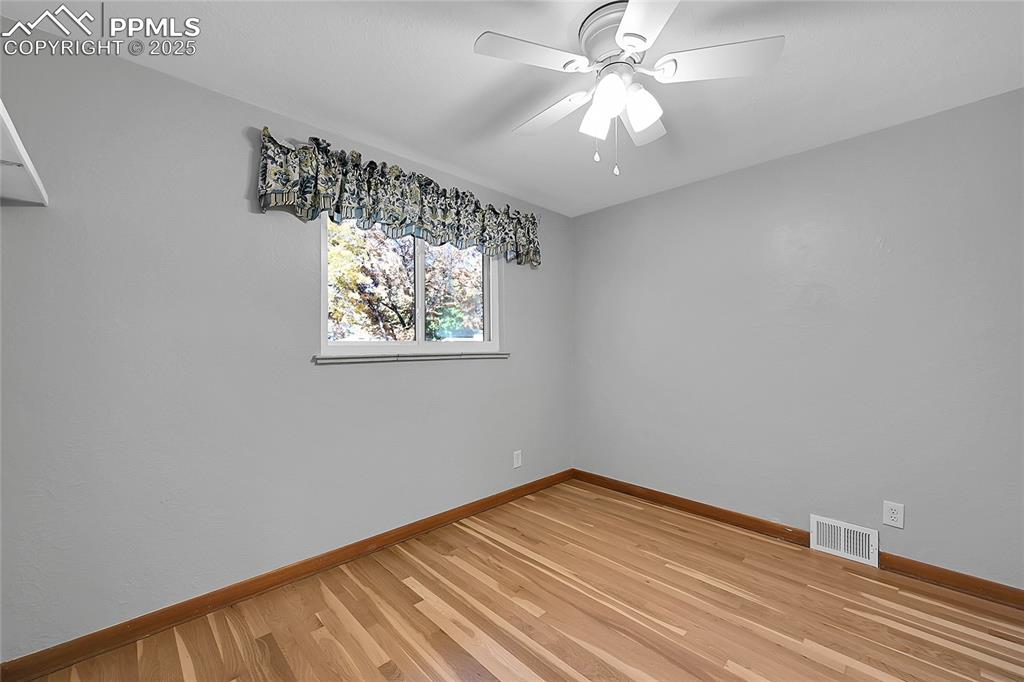 Image 15 of 27: Empty room featuring light wood-style floors and a ceiling fan