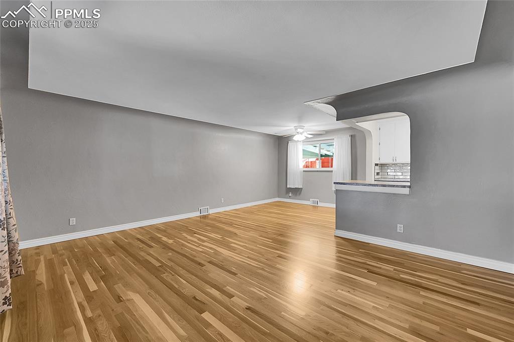 Image 2 of 27: Unfurnished living room featuring light wood-style floors and a ceiling fan