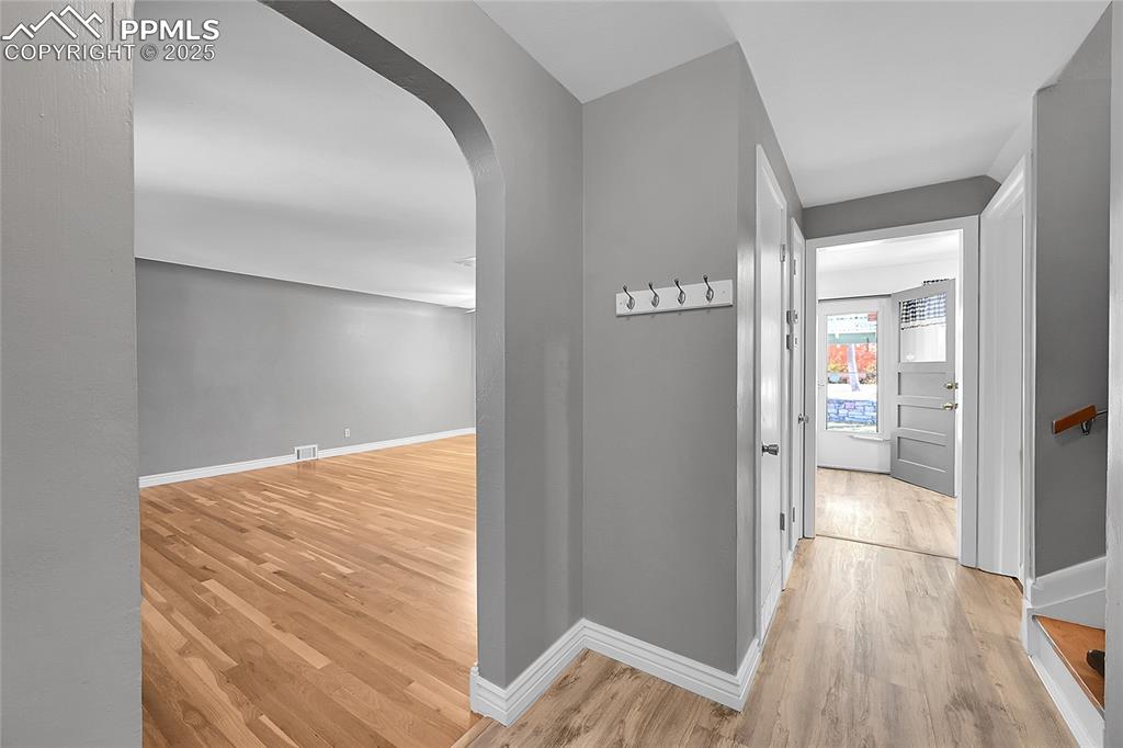 Image 5 of 27: Corridor featuring arched walkways and light wood-style floors