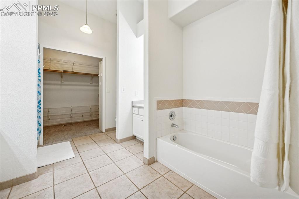 Image 23 of 37: HUGE primary bath with tub, single vanity and toilet on the right, closet s