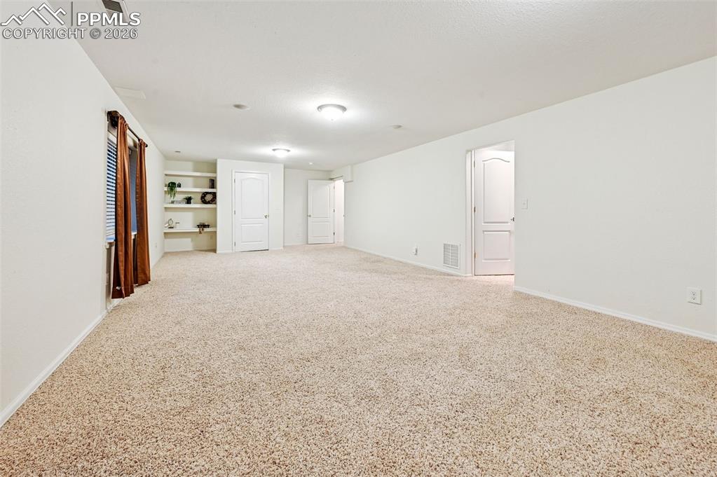 Image 30 of 37: Built-in bookshelves. Small crawl space through the far door