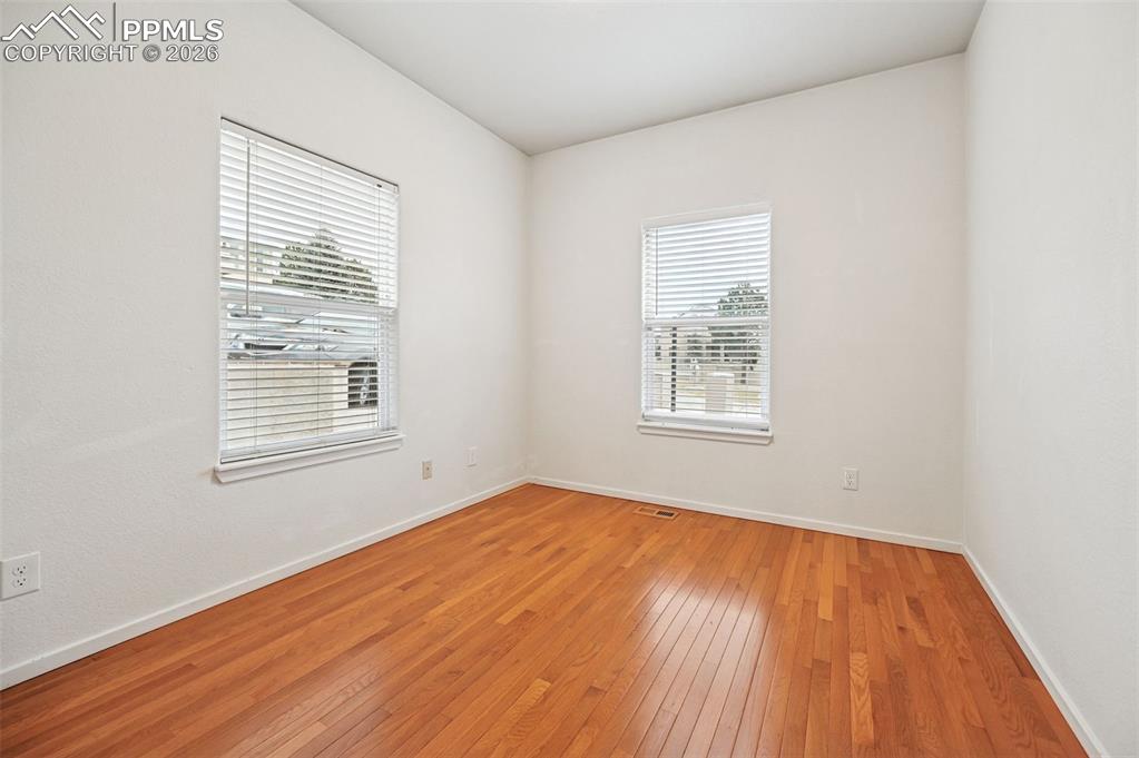 Image 9 of 37: Front bedroom on main level with hardwood floors