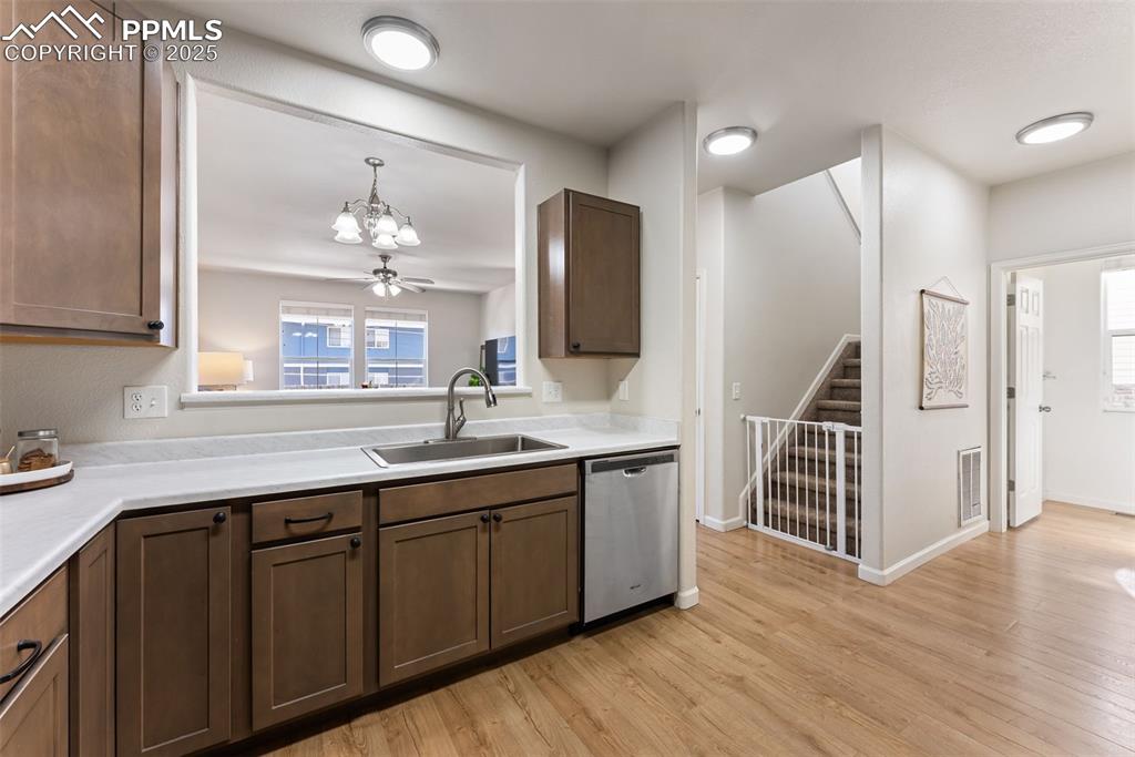 Image 11 of 34: Kitchen featuring light wood finished floors, dishwasher, light countertops