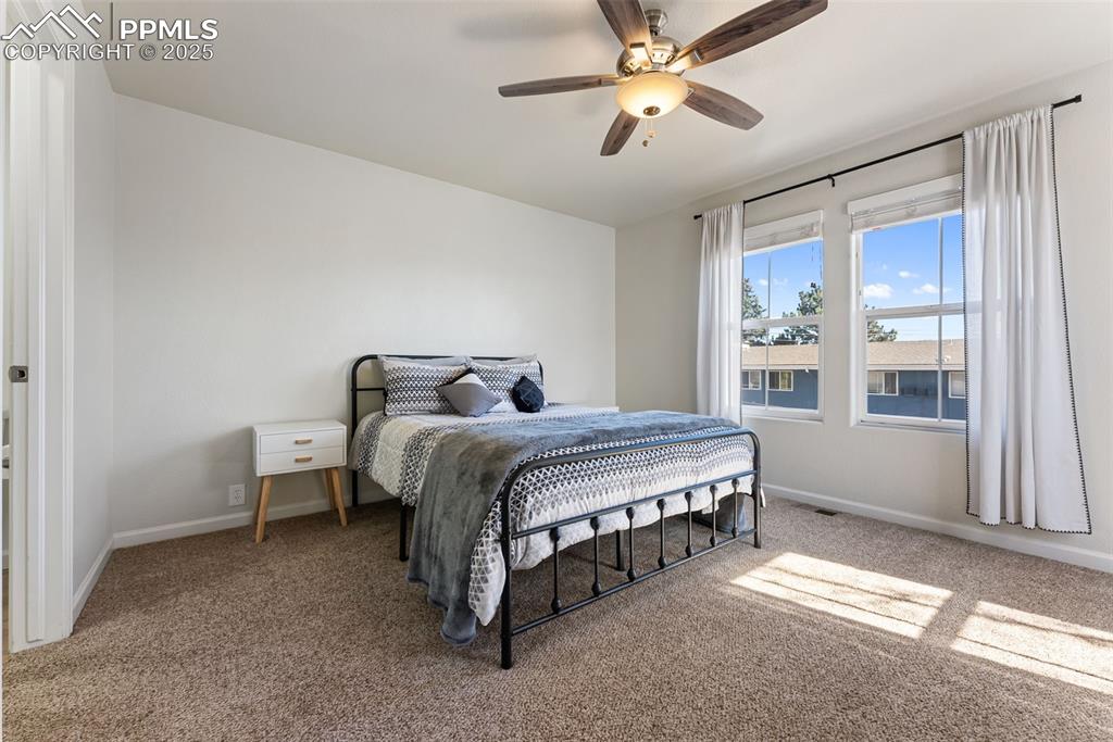 Image 15 of 34: Carpeted bedroom with ceiling fan and baseboards